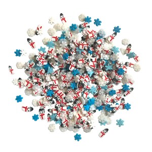 Op de afbeelding: Een mix van witte, blauwe en rode sprinkles in de vorm van sneeuwpoppen en sneeuwvlokken. De sprinkles zijn perfect om taarten, cupcakes en andere desserts te versieren.