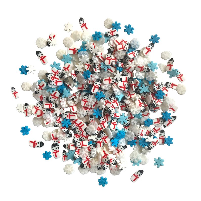 Op de afbeelding: Een mix van witte, blauwe en rode sprinkles in de vorm van sneeuwpoppen en sneeuwvlokken. De sprinkles zijn perfect om taarten, cupcakes en andere desserts te versieren.