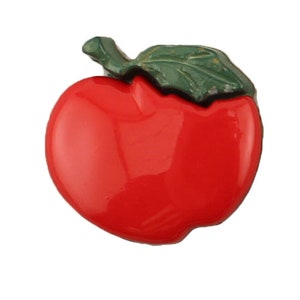 May include: A red apple button with a green leaf on top. The button is shiny and has a glossy finish.