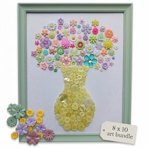 May include: A framed art piece featuring a vase made of yellow buttons, holding a bouquet of colorful flower-shaped buttons. The frame is light green, and the artwork is labeled "8 x 10 art bundle". Additional flower buttons are scattered below the frame.