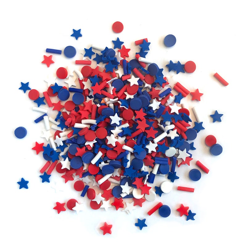 Op de afbeelding: Een verzameling rode, witte en blauwe sprinkles in de vorm van sterren en cirkels. De sprinkles zijn perfect om taarten, cupcakes en andere desserts te versieren.