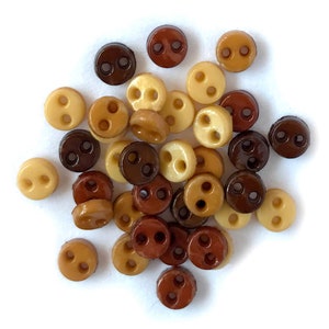 May include: A collection of small, two-hole buttons in brown, tan, and cream colors.