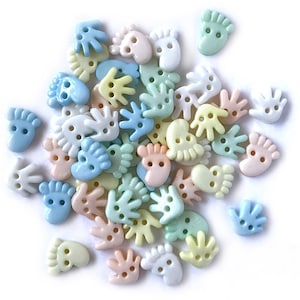 May include: Assortment of pastel colored plastic buttons in the shapes of hands and feet. The buttons have two holes each.