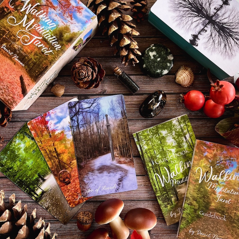 May include: A set of tarot cards with a guidebook. The cards feature nature scenes with autumn leaves and a forest path. The guidebook has the title "Walking Meditation Tarot" and the author's name "Daniel Norman".