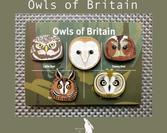 May include: A set of five enamel pins featuring different owls, including a Tawny Owl, Little Owl, Barn Owl, Long-eared Owl, and Short-eared Owl. The pins are arranged on a card with the text "Owls of Britain" and "Norfolk by Nature".