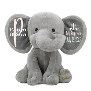 May include: Gray plush elephant stuffed animal with embroidered details. One ear says "Paige Olivia" with a pink "P". The other ear says "My Baptism July 09, 2023" with a cross and leaves.