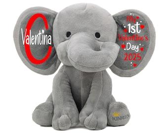 Puede incluir: Elefante de peluche gris con un corazón rojo y el texto "Valentina" en una oreja y el texto "My 1st Valentine's Day 2025" en la otra oreja.