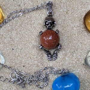 Necklace of a Skeleton Holding a Sphere of Jade...or Quartz, Obsidian, Blue Sandstone, Goldstone Gold Sandstone