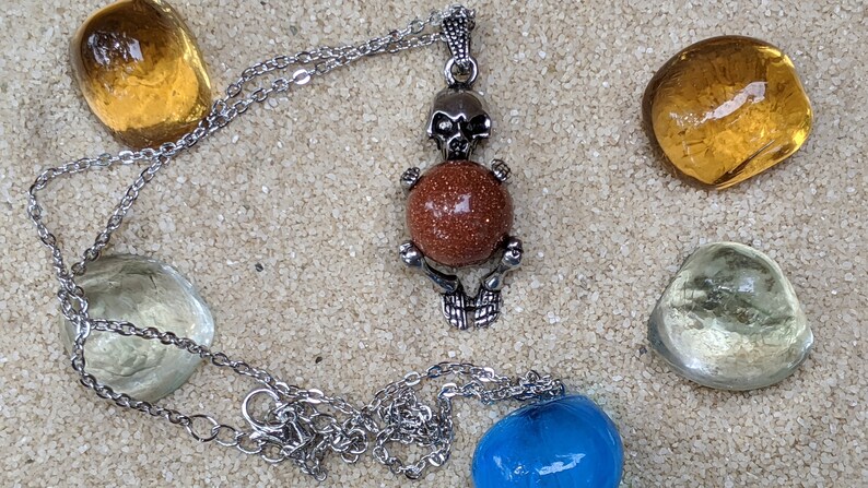 Necklace of a Skeleton Holding a Sphere of Jade...or Quartz, Obsidian, Blue Sandstone, Goldstone Gold Sandstone