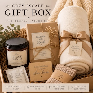 Peut inclure: Coffret cadeau "Cozy Escape" avec une couverture en peluche (152 cm x 203 cm), une bougie, un livre, du th&eacute; et des chaussettes. Le coffret comprend &eacute;galement un livre, du th&eacute; et des chaussettes. Le coffret contient le texte "The Perfect Night In".