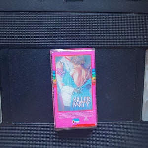 May include: A pink VHS tape case with the title "Killer Party" in white text. The cover art features a woman in a blue dress. The tape is set against a black background.