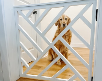 May include: A white wooden gate with a geometric design, featuring a golden retriever dog looking through the gate.