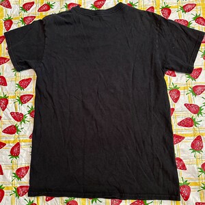Puede incluir: Camiseta negra de manga corta con cuello redondo.