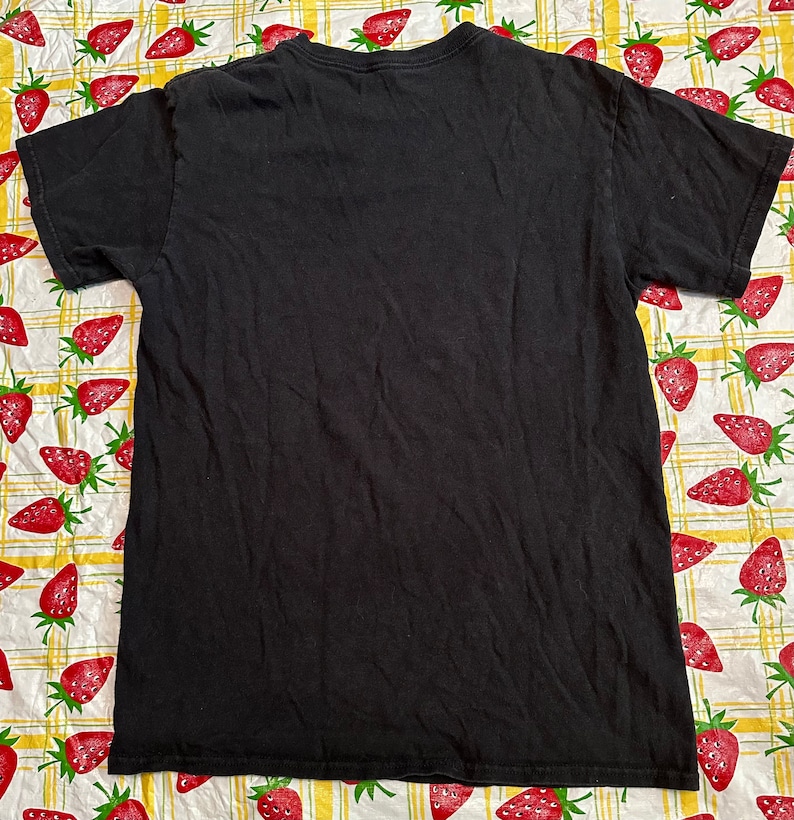 Puede incluir: Camiseta negra de manga corta con cuello redondo.