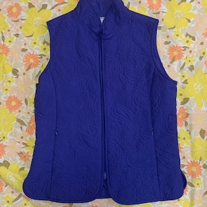 May include: A purple quilted vest with a zip fastening and a stand-up collar.