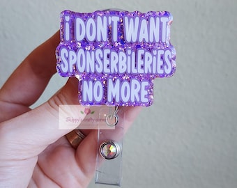 Puede incluir: Un portatarjetas de purpurina morada con el texto blanco I DON'T WANT SPONSERBILERIES NO MORE. El portatarjetas tiene una correa de plástico transparente con un botón de presión de metal plateado y un pequeño adorno de estrás circular.