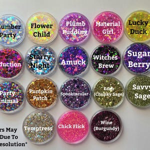 May include: A collection of seventeen circular containers filled with various coloured craft glitters. Each container features a label with names including Slumber Party, Flower Child, Plumb Pudding, Material Girl, Lucky Duck, Seduction, Starry Night, Amuck, Witches Brew, Sugar Berry, Party Animal, Pumpkin Patch, Spooktacular, Eden, Savvy Sage, Temptress, Chick Flick, and Wine.