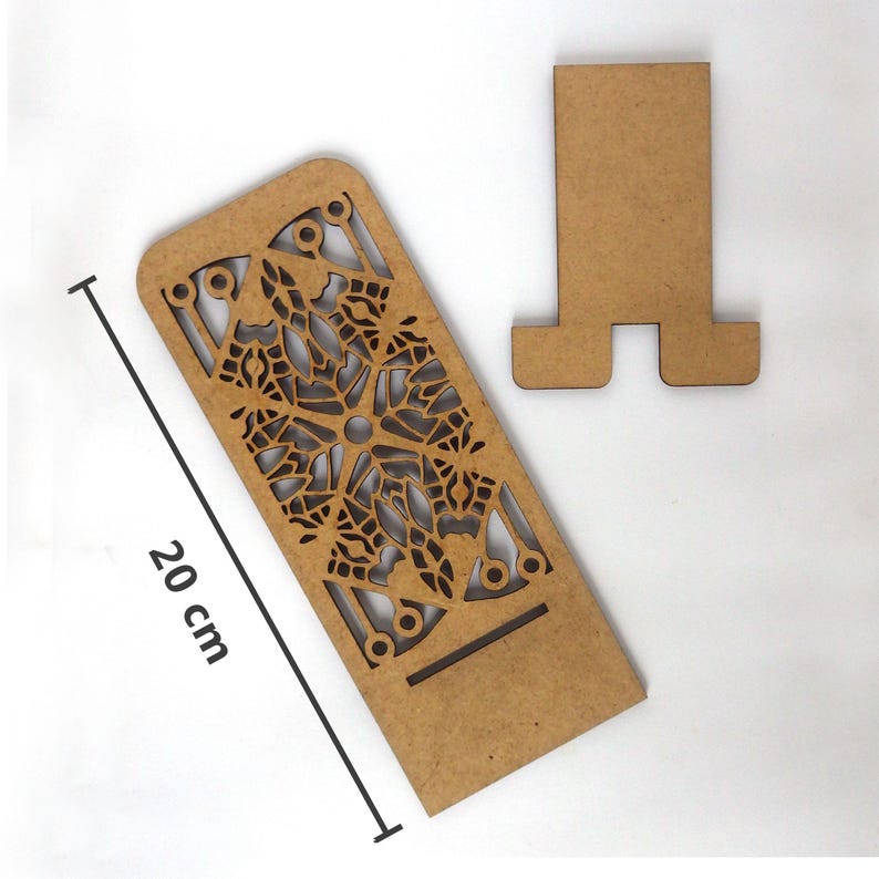 Puede incluir: Un soporte de tel&eacute;fono de madera con un dise&ntilde;o decorativo de corte. El soporte tiene 20 cm de alto y una base separada.