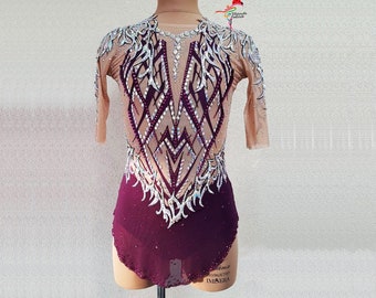 May include: A burgundy and nude-colored leotard with intricate rhinestone and sequin embellishments. The long-sleeved garment features a geometric design on the bodice and sleeves, perfect for rhythmic gymnastics or dance performances.