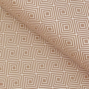 Könnte beinhalten: Ein brauner Stoff mit einem weißen geometrischen Muster aus Quadraten in Quadraten.