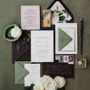 May include: A wedding invitation suite with a green and white color scheme. The invitation features a delicate floral design and the text "Alexa and Michael Andre". The RSVP card is a simple white card with a green envelope. The invitation is accompanied by a small box with a ring inside.