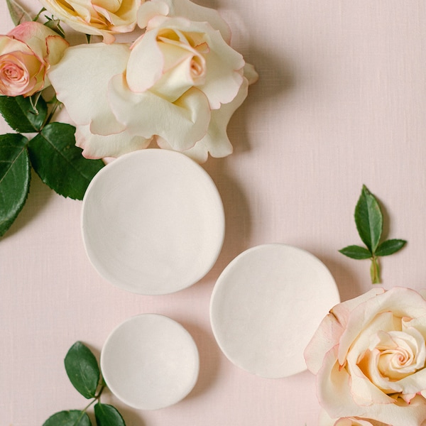 Petits plats en céramique brute utilisés pour les flatlays et les accessoires de mariage. Alliances et paraboles