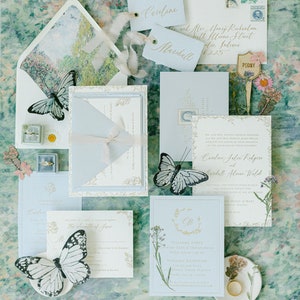 May include: A set of wedding invitations with a blue and white color scheme. The invitations feature a floral design with butterflies and the text "Welcome Party" and "Wedding Reception".