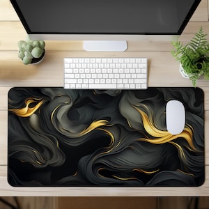 Puede incluir: Un tapete de ratón de diseño abstracto negro y dorado con patrones en espiral. El tapete de ratón está hecho de un material liso y antideslizante y es perfecto para usar con un ratón de computadora.