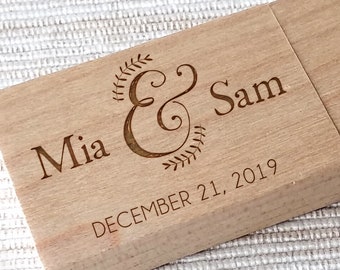 Op de afbeelding: Een houten USB-stick met de tekst "Mia & Sam" en "DECEMBER 21, 2019" erop gegraveerd.