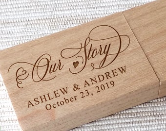 May include: A wooden USB drive with the text "Our Story" in a cursive font, a small heart symbol, and the names "Ashlew & Andrew" and the date "October 23, 2019".