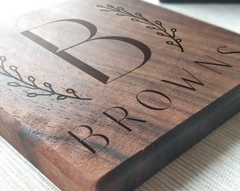 Op de afbeelding: Een houten bord met de letter "B" en het woord "BROWNS" erop gegraveerd. Het bord is gemaakt van walnoot hout en heeft een natuurlijke hout afwerking.
