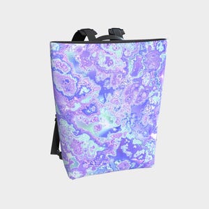 May include: A backpack featuring an abstract design in shades of purple, blue, and white. The bag has black straps and a top handle. The pattern resembles a marbled effect, giving it a unique and striking appearance. The bag is suitable for carrying items.