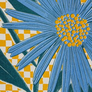 May include: A detailed image of a blue flower with a yellow centre and long petals. The background has a yellow and white chequered pattern and dark green leaves, forming a bright floral design.