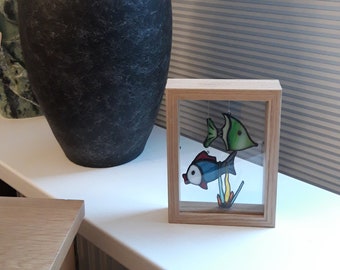 Fish of glass hanging in a picture frame