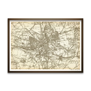 May include: A framed vintage map of Newcastle upon Tyne, England, in sepia tones. The map details the city's layout, including streets, buildings, and the River Tyne. The map is in a dark brown frame.