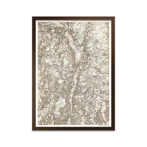 May include: A framed vintage map print with a dark brown wooden frame. The map is in sepia tones, depicting a detailed topographical view with a long, narrow lake. The print is a historical piece.