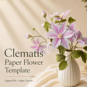 May include: A bouquet of handcrafted paper clematis flowers in shades of pink and white with green leaves, arranged in a ribbed white ceramic vase. The text reads Clematis Paper Flower Template, Digital PDF + Video Tutorial.