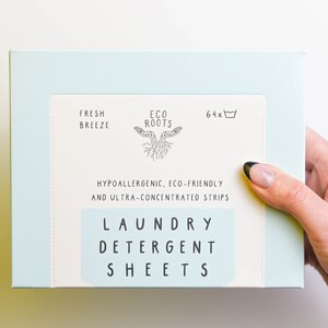 Puede incluir: Una caja de color azul claro de hojas de detergente para la ropa con el texto "Fresh Breeze" y "Eco Roots" en la parte delantera. La caja tambi&eacute;n dice "Hipoalerg&eacute;nico, ecol&oacute;gico y ultraconcentrado" y "Hojas de detergente para la ropa".