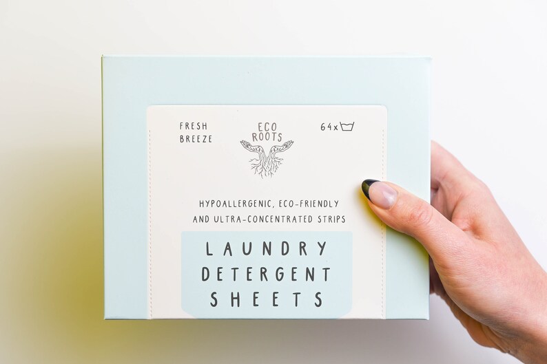 Puede incluir: Una caja de color azul claro de hojas de detergente para la ropa con el texto "Fresh Breeze" y "Eco Roots" en la parte delantera. La caja tambi&eacute;n dice "Hipoalerg&eacute;nico, ecol&oacute;gico y ultraconcentrado" y "Hojas de detergente para la ropa".
