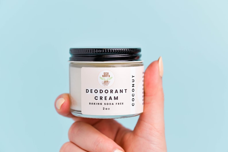 May include: A white jar with a black lid containing a coconut deodorant cream. The jar has a label that reads "Eco Roots Deodorant Cream Baking Soda Free 2 oz Coconut".