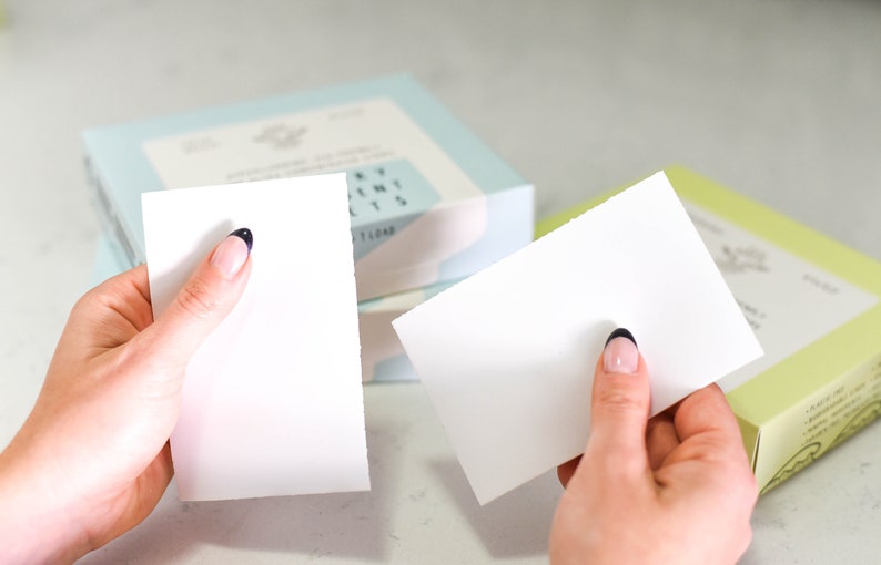 Puede incluir: Dos blocs de papel rectangulares blancos con esquinas redondeadas, sostenidos en manos. Los blocs est&aacute;n en blanco y parecen ser para tomar notas.
