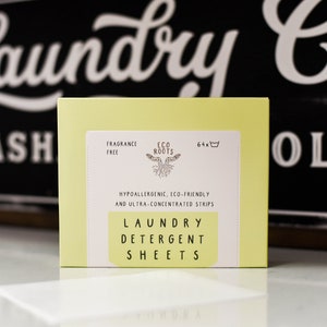 Puede incluir: Una caja amarilla de 64 hojas de detergente para la ropa de Eco Roots. La caja est&aacute; etiquetada como "sin perfume", "hipoalerg&eacute;nica", "ecol&oacute;gica" y "ultra concentrada".
