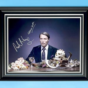 Fotografía firmada por Mads Mikkelsen en un lujoso marco de madera hecho a mano y póster de Hannibal Lecter con el certificado de autenticidad de un miembro de AFTAL, recuerdos de películas y programas de televisión