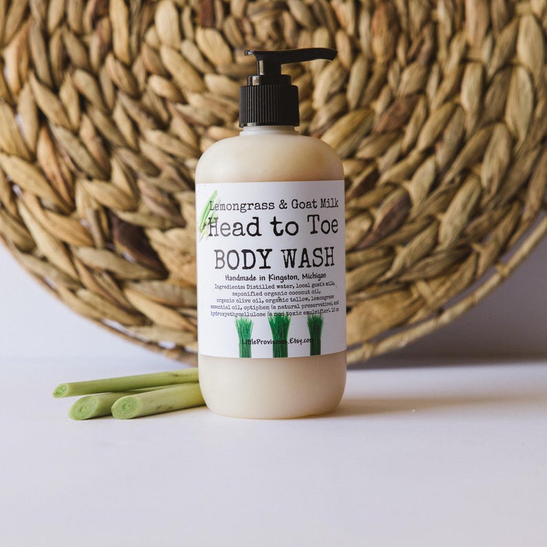 Op de afbeelding: Een doorzichtige plastic fles met lemongrass en geitenmelk head-to-toe body wash. De fles heeft een pompdispenser en een wit etiket met zwarte tekst die "Lemongrass & Goat Milk Head to Toe BODY WASH Handmade in Kingston, Michigan Ingredients: Distilled water, local goat milk, saponified organic coconut oil, organic olive oil, organic tallow, lemongrass essential oil, optiphen is natural preservative,  hydrolyzed jojoba protein,  non-GMO sunflower oil. LittleProvinceEtsy.com" leest.