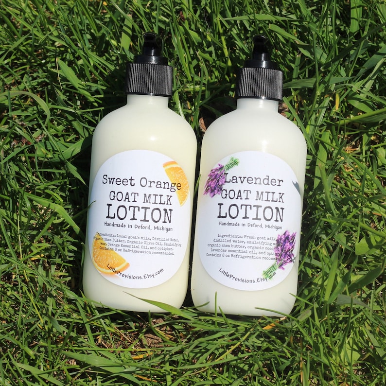 May include: Two white plastic bottles of goat milk lotion, one with a sweet orange scent and the other with a lavender scent. Both bottles have black pump tops and white labels with the product name, ingredients, and the Etsy shop name "Little Provisions".