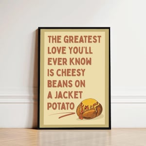 May include: A framed print with the text "THE GREATEST LOVE YOU'LL EVER KNOW IS CHEESY BEANS ON A JACKET POTATO." The image shows a cartoon illustration of a baked potato topped with cheese and beans. The background is a light beige colour.