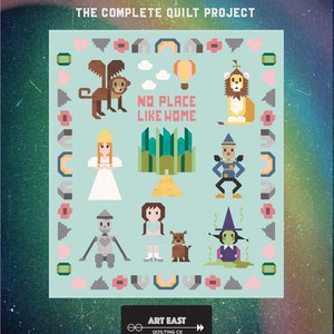 May include: A quilt project with the text "SEW PLACE LIKE HOME" and "THE COMPLETE QUILT PROJECT". The quilt features pixelated illustrations of characters and elements from The Wizard of Oz, including a lion, a witch, and the text "NO PLACE LIKE HOME".