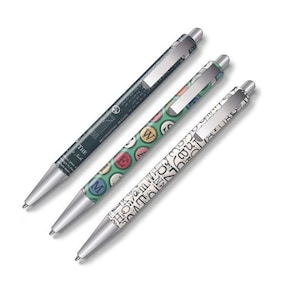 May include: Three ballpoint pens with silver tips and clips. One pen is dark teal with white text, another is green with colourful circles, and the third is white with black letters. The pens are angled on a white background.