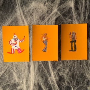 May include: Three illustrated cards with a yellow background. The first card features a clown with a red and white costume holding a red balloon. The second card features a woman with a red bandana and a blue denim jacket. The third card features a man with a black mask and a black and green outfit holding two guns.