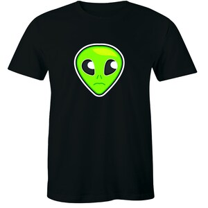 May include: Black t-shirt with a green alien face graphic. The alien has large eyes and a sad expression.